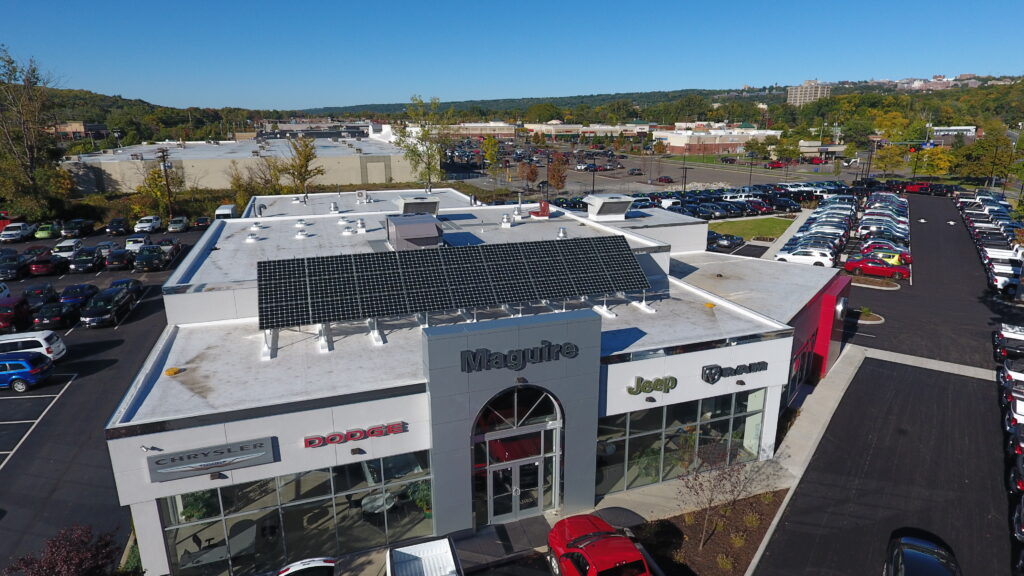 solar panels on a car dealership roof with blue sky in the background